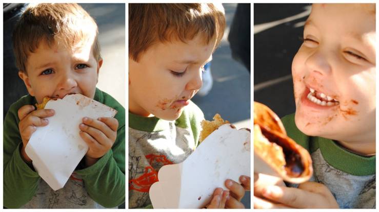 Young child with short brown hair, eating crepes and smiling