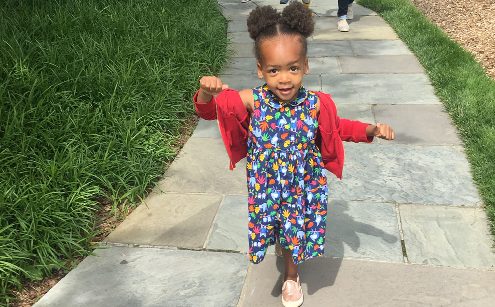 preschooler walking happily down a path through Hillwood's gardens