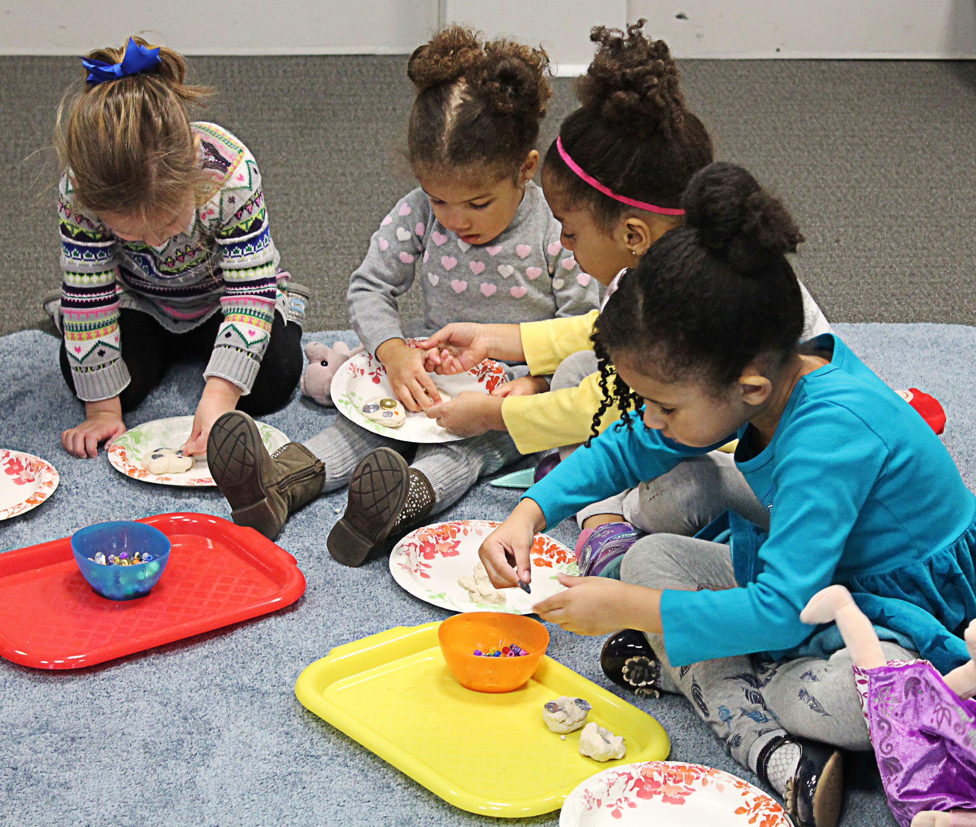 preschoolers sitting on carpet working on art project